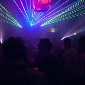 Kleurrijke lasershow tijdens een voorstelling in De Groene Zwaan, intiem theater en concertpodium.